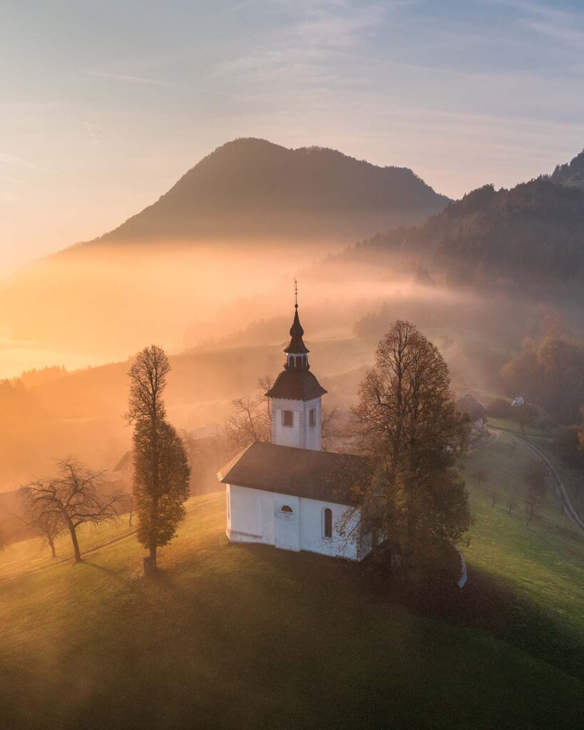 aerial view of small church on the hill in low clo vktrdek.jpg