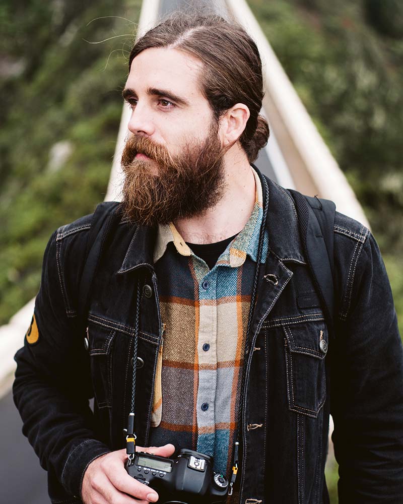 bearded photographer looking away on mountain road ugfmxud.jpg